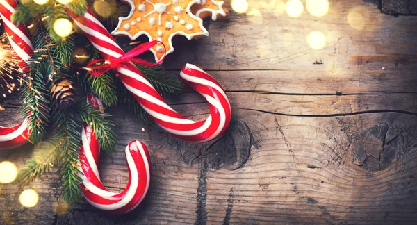 圣诞姜饼饼干 糖果手杖和冷杉树枝在木桌上 — 图库照片