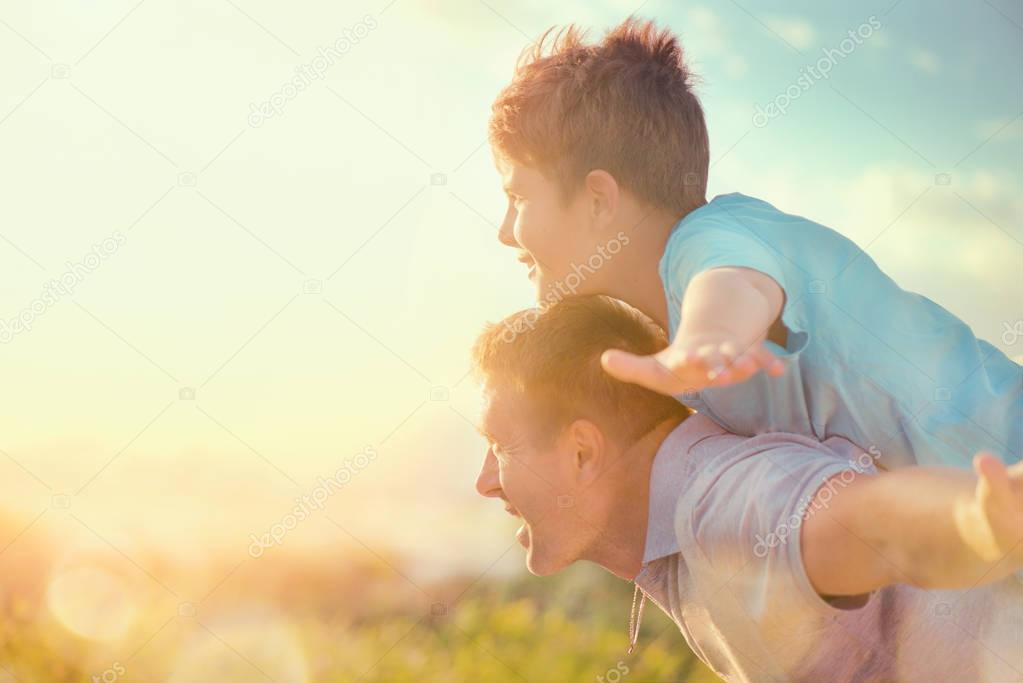 father and son having fun over sky outdoors