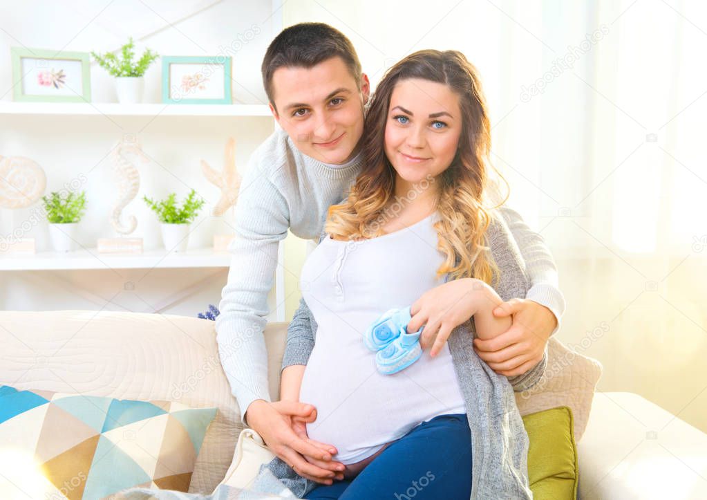 Pregnant woman and husband together caressing pregnant belly