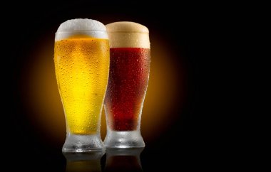 Two glasses of cold light and dark beer on black background clipart