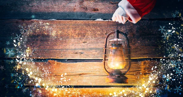 Santa Rękę Trzymając Lampa Naftowa Vintage Podłoże Drewniane — Zdjęcie stockowe