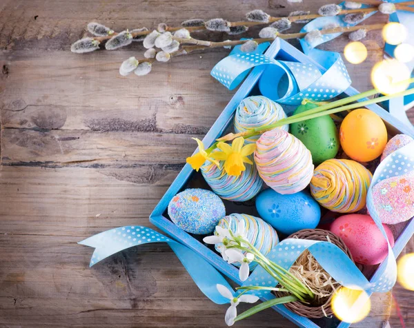 Pasen Kleurrijk Geschilderd Eieren Met Lentebloemen Blauw Satijnen Lint Houten — Stockfoto