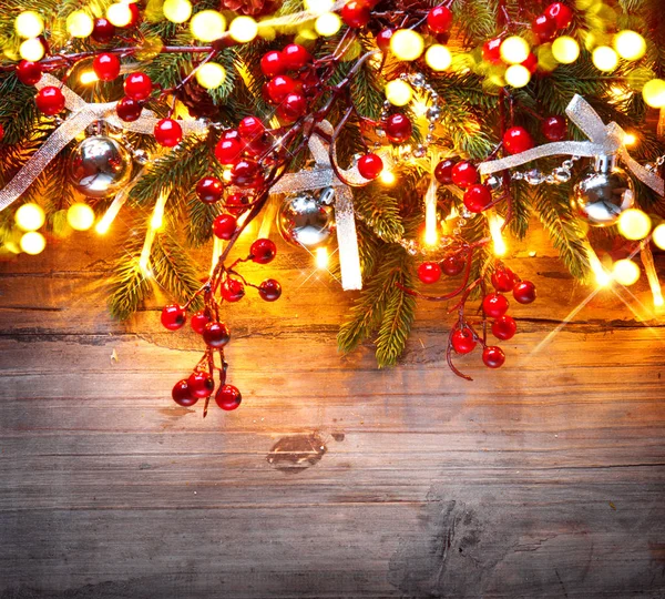 木制背景下的圣诞树装饰灯和浆果 — 图库照片