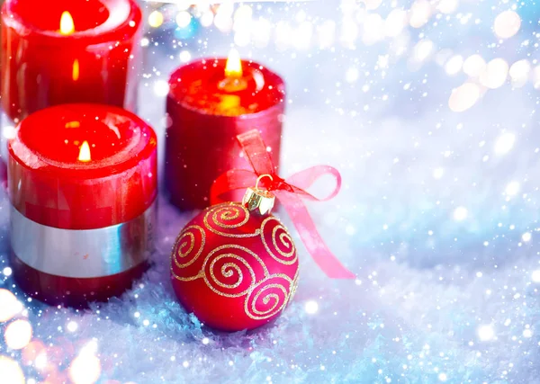 赤いクリスマスの装飾と白い雪の背景の上のキャンドル — ストック写真