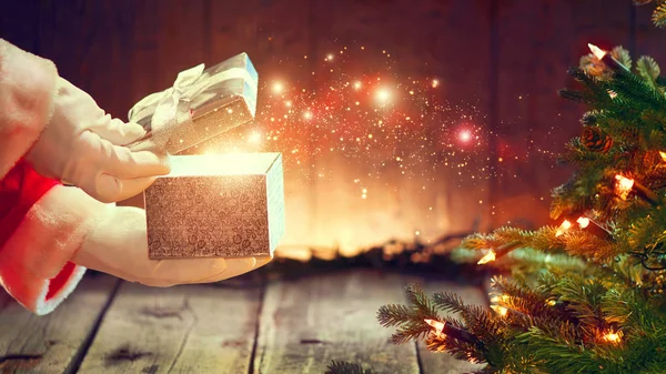 Weihnachtsmann Öffnet Geschenkbox Mit Funkeln Über Holzhintergrund — Stockfoto