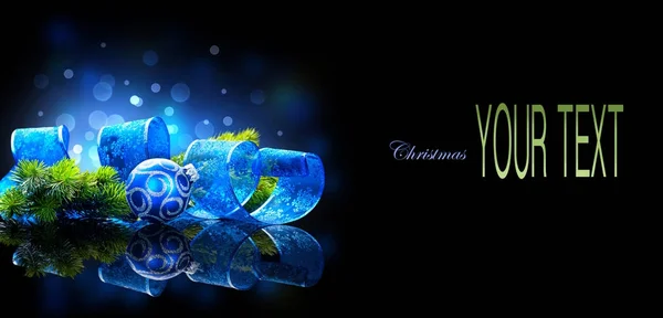 蓝色圣诞装饰球与冷杉分支和丝带在黑背景 与空间为文本 图库图片