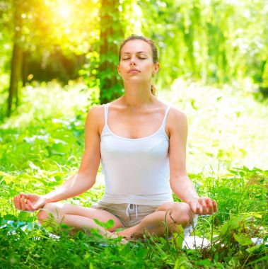 Dışarıda yoga egzersizi yapan genç bir kadın.