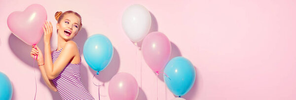 радостная девочка-подросток с красочными воздушными шарами, веселящимися на розовом фоне
