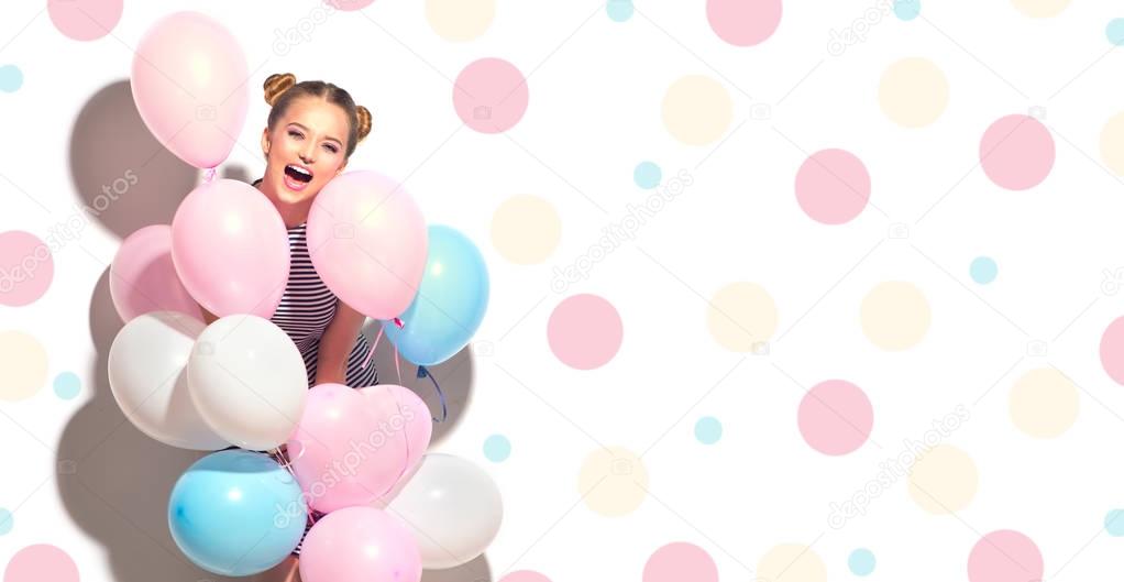 joyful teenage girl with colorful air balloons having fun over white background with dots