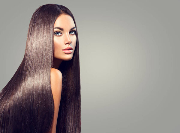 woman with long straight black hair on grey background