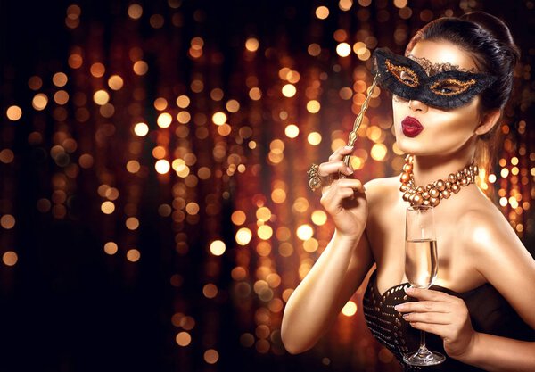 woman with glass of champagne and lace masquerade mask on face