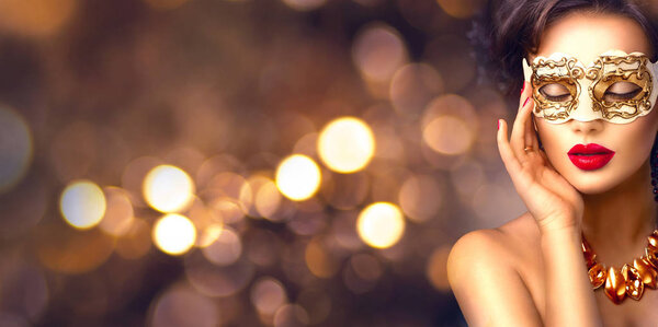 woman in golden masquerade carnival mask with bokeh on background