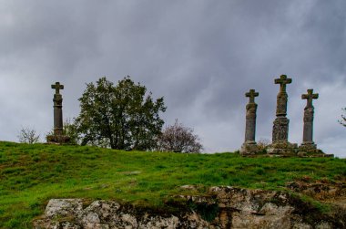 Paisaje con una conjunto de cruces gallegas (haç) en una montaa, con arboles detras