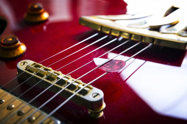 Guitarra acústica vermelha com plectro — Fotografia de Stock