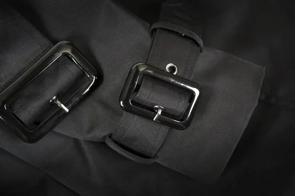 Черная пластиковая пряжка на черном фоне ткани — стоковое фото