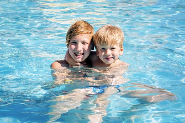 Due fratelli sorridenti in piscina . Foto Stock
