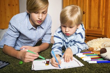 Katta oturan ve çizim kardeşler