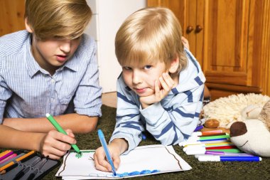 Katta oturan ve çizim kardeşler