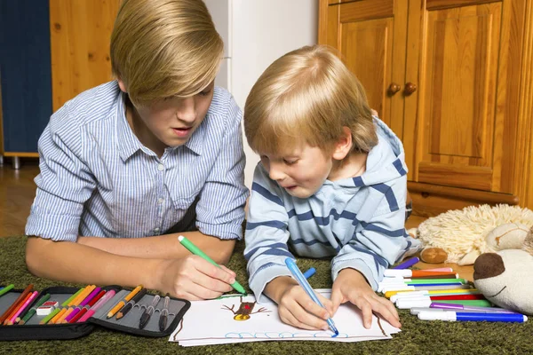 Siblings sitting on the floor and drawing — Stock Photo, Image