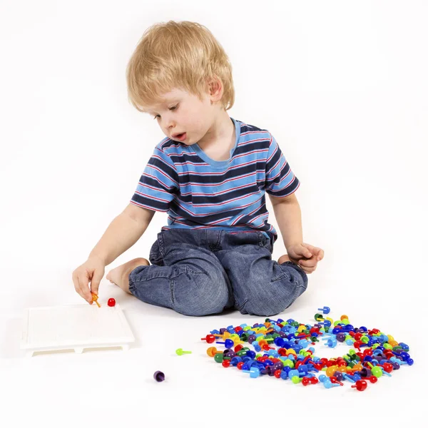 Criança brinca com um mosaico — Fotografia de Stock