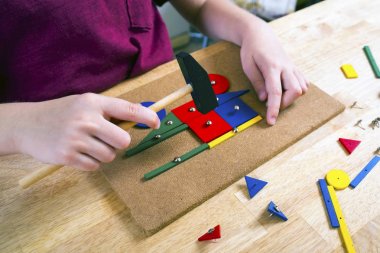 Blok ve çivi ile oynayan çocuk