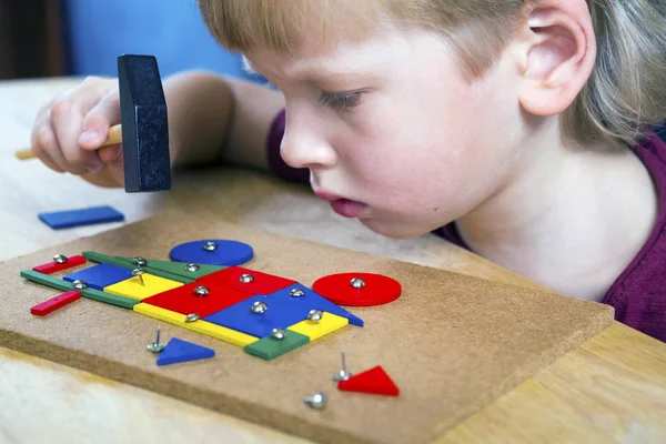 Мальчик играет с блоками и ногтями — стоковое фото