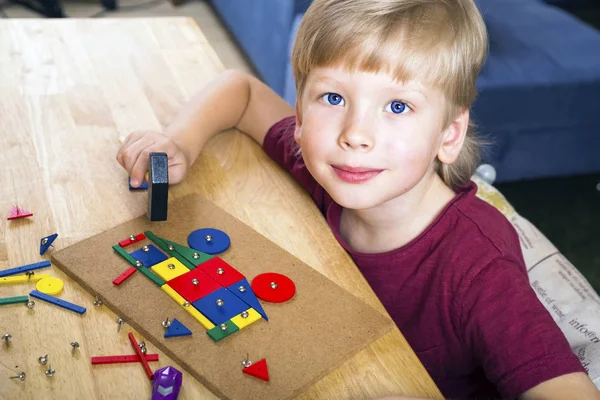 Menino brincando com blocos e unhas — Fotografia de Stock