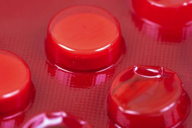 Beyaz kırmızı Vakumlu Ambalaj içinde tablet.