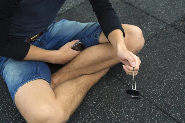 Ragazzo seduto e con gli occhiali da sole blu — Foto Stock