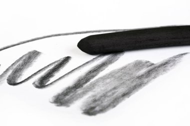 Bir beyaz kağıt üzerinde kömür sanat donanımları