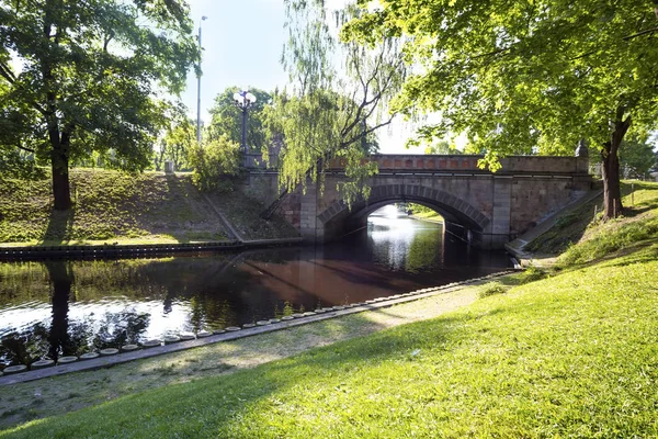 Puente a través del pequeño río en el parque —  Fotos de Stock