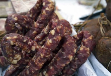 Geleneksel Litvanya, Klaipeda, Litvanya 'da geleneksel ürünler fuarında bir sokak pazarının tezgahında tütsülenmiş sosisi iyileştirdi.