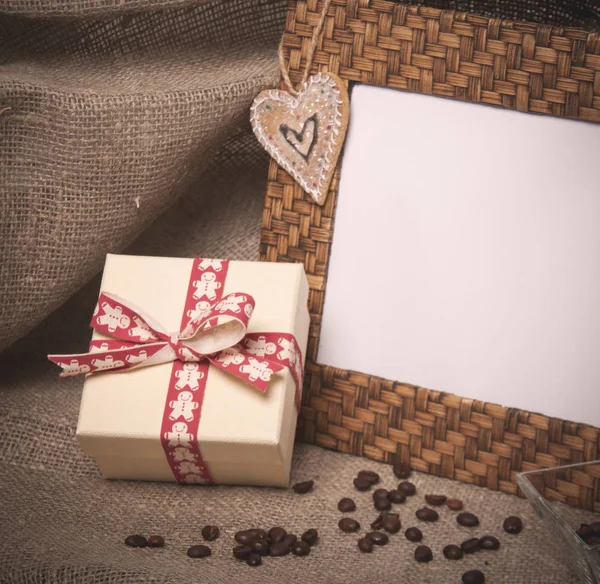 Desktop foto moldura e grãos de café com caixa de presente em linho — Fotografia de Stock