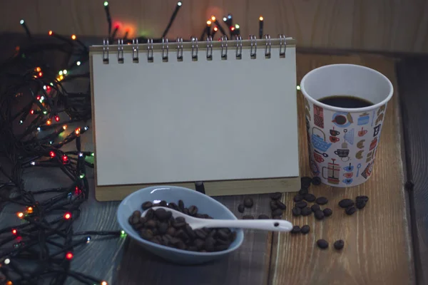 Notepad, a glass  and coffee beans in a bowl — Stock Photo, Image