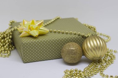 Hediye kutusu ve iki Noel topları hafif bir arka plan üzerinde