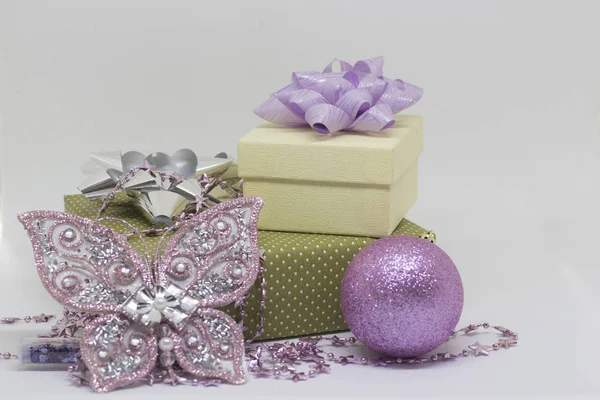 Dos cajas de regalo, una mariposa y una pelota sobre un fondo blanco — Foto de Stock