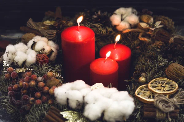 Red burning christmas candles in a pine wreath — Stock Photo, Image