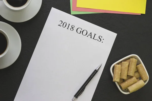 2018 objetivos papel com xícaras de café, uma caneta e uma tigela de biscoitos — Fotografia de Stock