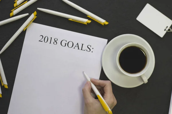 Hand writing New Years resolutions , white pens and a badge — Stock Photo, Image