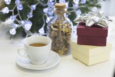 Bir fincan çay, kuru çiçekler ve giftboxes cam şişe ile şenlikli parlak sabah