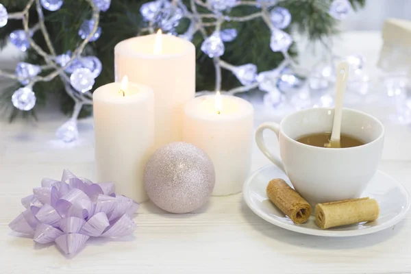 A festive still life with tea, Christmas decorations and candles, light colors — Stock Photo, Image