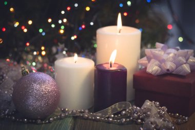 Yanan mumlar, Noel süsleri ve bir hediye kutusu ile natürmort