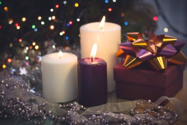 Yanan mumlar, Noel süsleri ve bir hediye kutusu ile natürmort