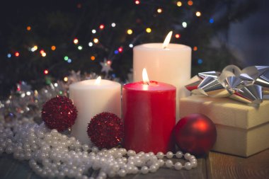 Yanan mumlar, Noel süsleri ve bir hediye kutusu ile natürmort