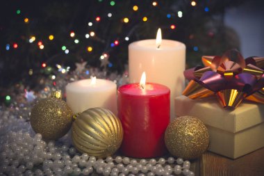 Yanan mumlar, Noel süsleri ve bir hediye kutusu ile natürmort