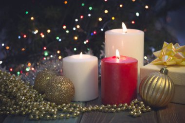 Yanan mumlar, Noel süsleri ve bir hediye kutusu ile natürmort