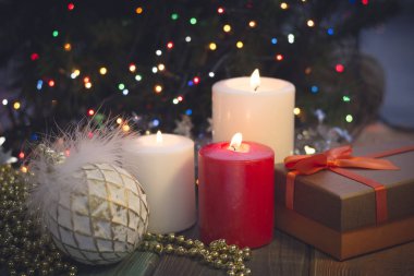 Yanan mumlar, Noel süsleri ve bir hediye kutusu ile natürmort