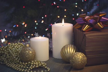 Yanan mumlar, Noel süsleri ve bir hediye kutusu ile natürmort