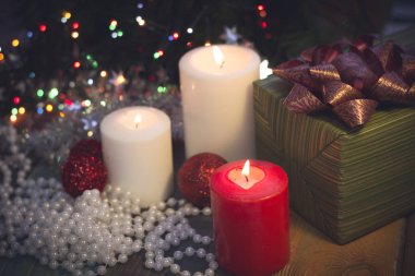 Yanan mumlar, Noel süsleri ve bir hediye kutusu ile natürmort