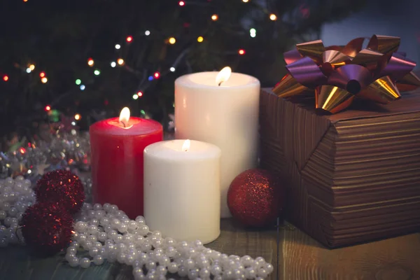 Yanan mumlar, Noel süsleri ve bir hediye kutusu ile natürmort